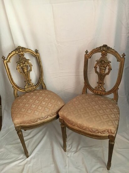 A pair of carved and gilded wooden chairs,...