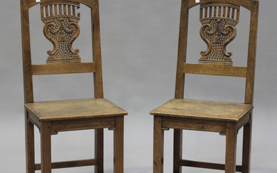 A pair of late 19th century French oak hall chairs with carved and pierced splat backs, the solid se