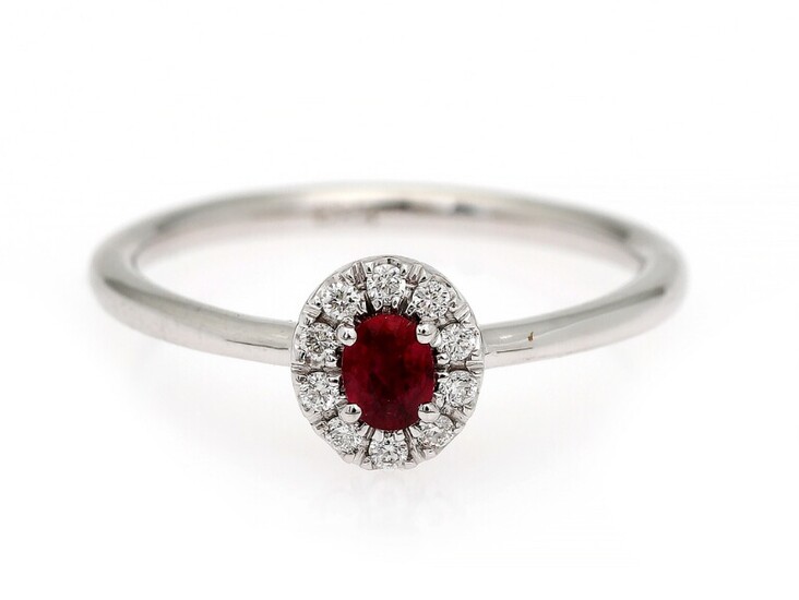 NOT SOLD. A ruby and diamond ring set with a ruby encircled by numerous diamonds,...