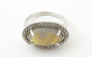 A silver ring set with opal cabochon. Ring size approx. P Please Note - we do not make reference to