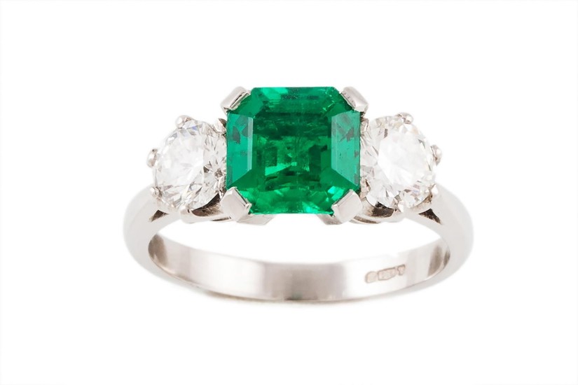 AN EMERALD AND DIAMOND THREE STONE RING, with one octagonal ...