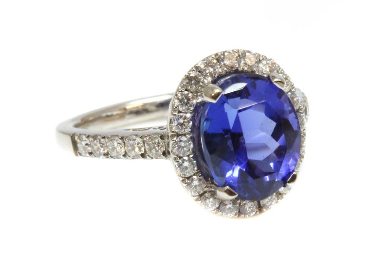 An 18ct white gold tanzanite and diamond oval halo cluster ring