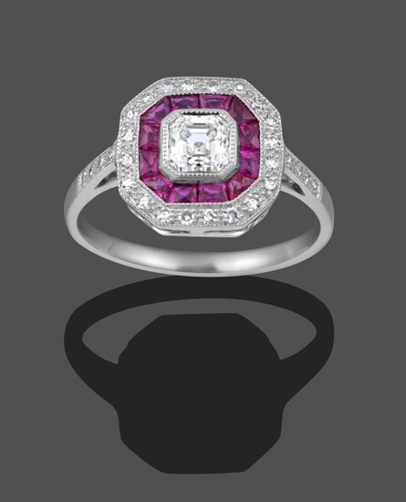 An Art Deco Style Ruby and Diamond Cluster Ring, the emerald-cut diamond to a border of step...