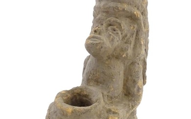 An Aztec Pre-Columbian style earthenware sculpture depicting a kneeling figure with a vessel.