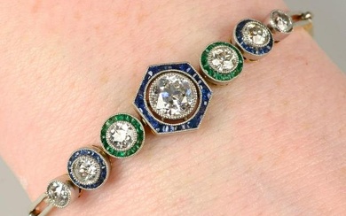 An old-cut diamond bracelet, with calibre-cut sapphire and emerald surrounds.Estimated total diamond