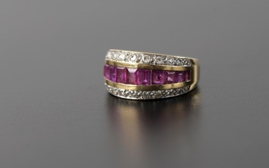 Banner ring in 18k yellow gold set with a line of twelve calibrated rubies of different sizes surrounded by two rows of twelve brilliant diamonds.