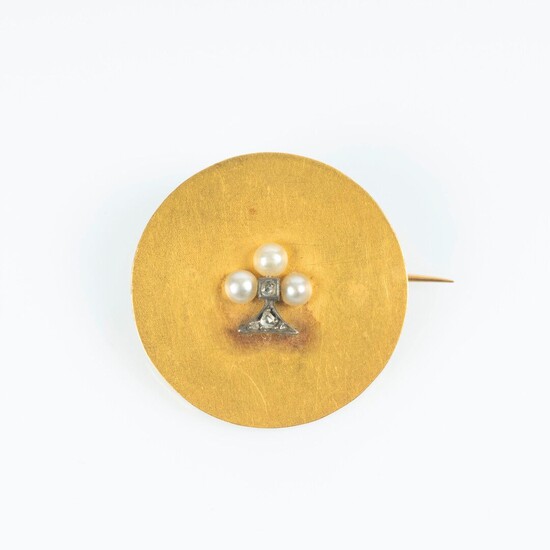 Broche en or, un disque uni piqué d'un motif trèfle serti de petites perles et...