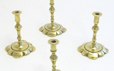 Four 19thC cast brass taper sticks with shaped bases.