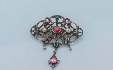 Gothic Revival style silver brooch (800 thousandths), centered on an oval-cut garnet on a paillon in closed settings, shouldered with two pearls, framed by four cabochon red stones and alternating with four rectangular green stones in closed settings...