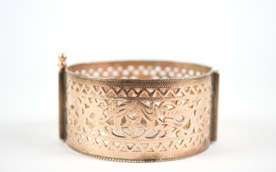 Large bracelet articulé en or jaune ajouré 14K à décor de feuillages et motifs géométriques...