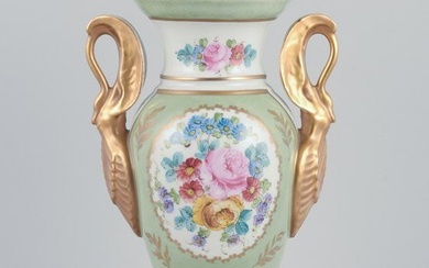 Limoges/Sevres, France. Porcelain vase on a pedestal, handles shaped like swans. Hand-decorated with