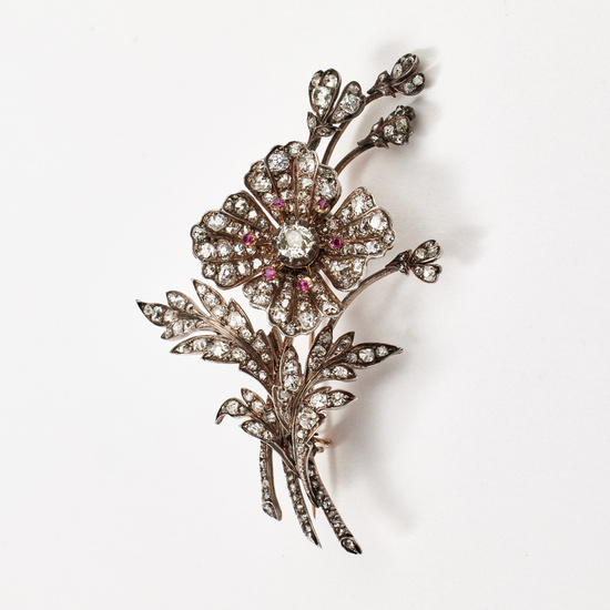 3171661. A gold/silver brooch, late 19th century, decorated with diamonds with old- antique-, resp, rose cut, pistils set with faceted rubies, in the form of a stylized flower.