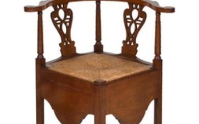 CHIPPENDALE CORNER CHAIR In mahogany. Back with raised crest rail and two pierced vertical splats. Scrolled arms. Slip rush seat. De...