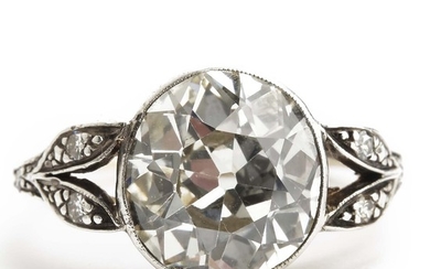 A Belle Èpoque diamond ring set with an old-cut diamond weighing app. 3.40 ct. flanked by single-cut diamonds, mounted in 14k gold and silver. Size 54. 1900.