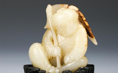 A CARVED WHITE JADE SEATED FIGURE