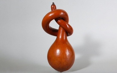 A CHINESE KNOTTED GOURD. Qing Dynasty, 19th Century. The bulbous body rising to a long slightly tapering neck, twisted into a loose knot, well patinated and of a rich ochre hue, 35cm long. Provenance: the property of a lady. 清 纏繞長頸葫蘆 來源：女士藏品。