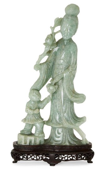 A Chinese jadeite figure of an immortal, mid-20th century, carved standing holding a lotus flower with a boy by her side, on fitted wood stand, 33.5cm high