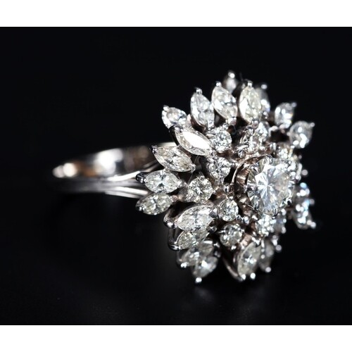 A DIAMOND CLUSTER RING claw set to the centre with a brillia...
