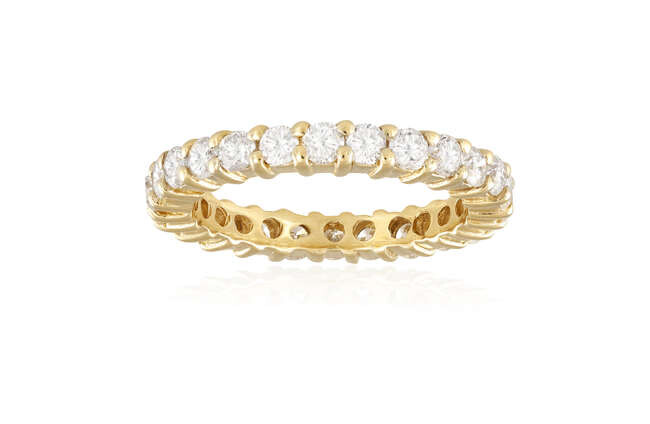 A DIAMOND ETERNITY RING Composed of a continuous...