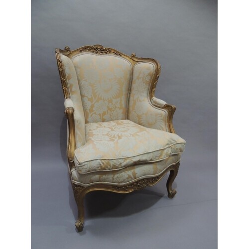 A French gilt armchair having an encircling moulded and flor...