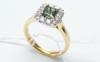 A GREEN SAPPHIRE AND DIAMOND RING IN TWO TONE 18CT GOLD, CENTRALLY SET WITH AN AUSTRALIAN GREEN SAPPHIRE SURROUNDED BY ROUND BRILLIA...