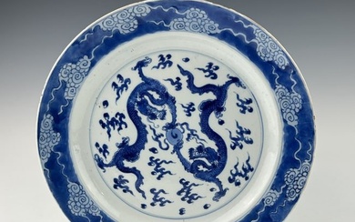 A LARGE CHINESE QING DYNASTY KANGXI BLUE AND WHITE DRAGON PLATE, 17TH CENTURY