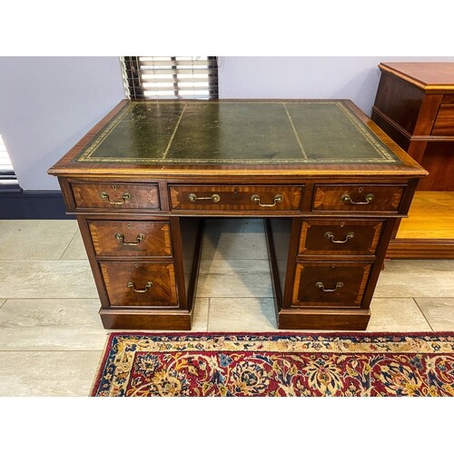 A MAHOGANY PEDESTAL DESK The moulded rectangular top with a...