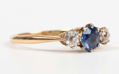 A gold, platinum, sapphire and diamond ring, claw set with a circular cut sapphire between two old c