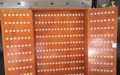 A hotel key cabinet with brackets and enamel number plates