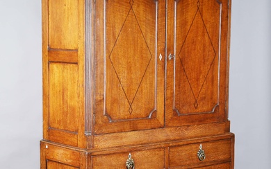 A late George III provincial oak press cupboard, the chequer inlaid pediment above two inlaid doors