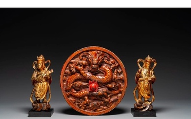 A pair of Chinese gilt-lacquered wooden guardians and a roun...