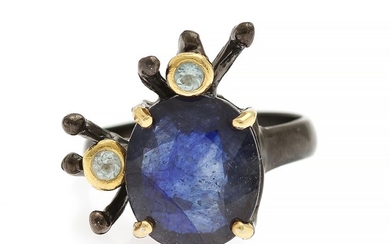 A sapphire and topaz ring set with a sapphire weighing app. 5.5 ct. and two topazes, mounted in black rhodium plated and partly gilded sterling silver. Size 57.