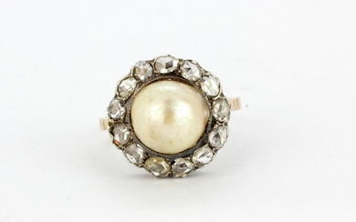 An antique yellow metal (tested minimum 9ct gold) ring set with a large pearl surrounded by rose cut diamonds, (O.5).