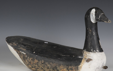 An early 20th century carved softwood decoy model of a Canada goose, height 34cm, length 59cm.