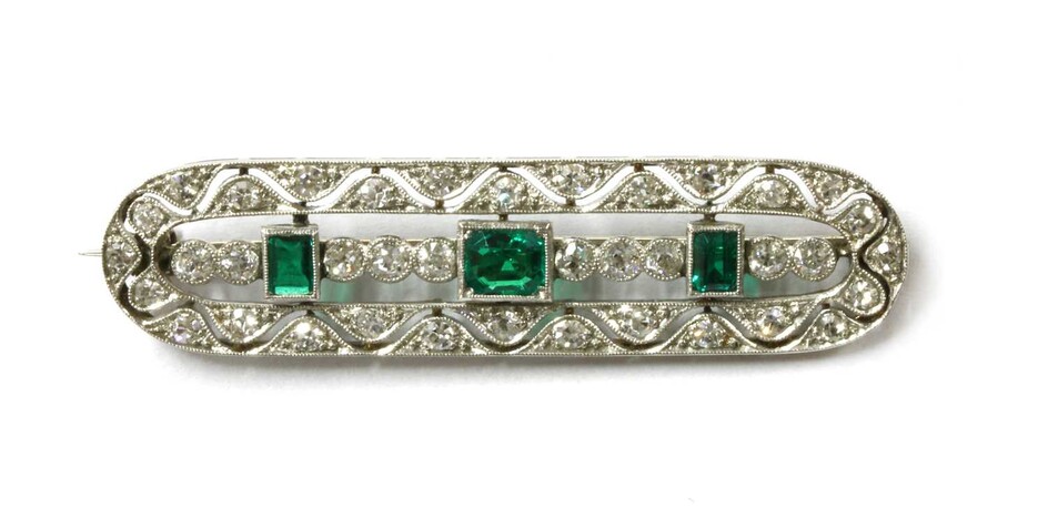 An early 20th century white gold emerald and diamond brooch
