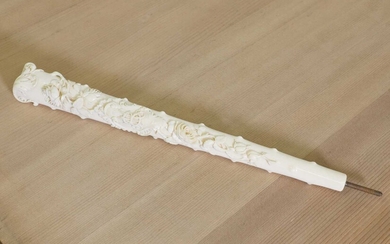 An ornately carved ivory parasol handle