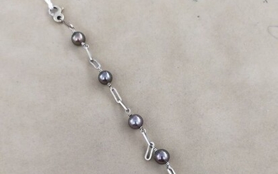 Bracelet en or gris 18K (750 millièmes) à maillons ajourés rehaussés de 5 perles de...