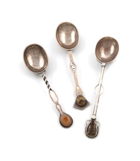 By Ellen Caroline Woodward, three Edwardian Arts and Crafts silver spoons, London 1905 and 1909, oval bowls, the pierced handles with hard stone finials, lengths 11.5cm, 10.5cm and 10.2cm, approx. weight 1.3oz. (3)