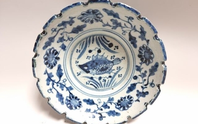 CHINE. PLAT en porcelaine bleu blanc à décor de poisson, aile crénelée, idéogrammes au revers....