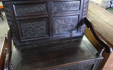 Carved dark oak hall bench with four carved panels...