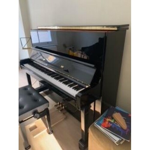 Kawai (c1977) An upright piano in a bright ebonised case. AM...