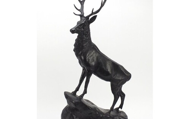 Large patinated bronze stag raised on a stepped marble base,...