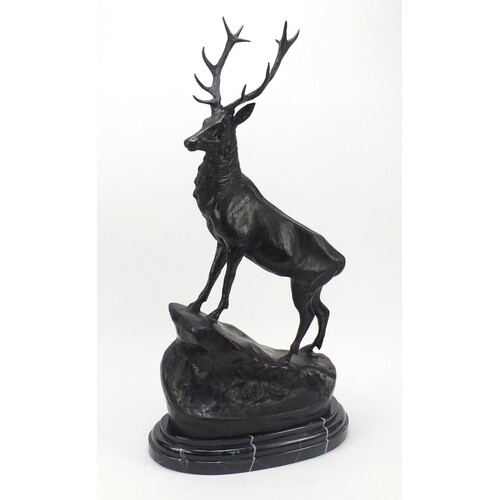Large patinated bronze stag raised on a stepped marble base,...
