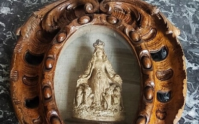 MÉDAILLON en chêne sculpté et ajouré à décor d’agrafes renfermant au centre une Vierge couronnée...
