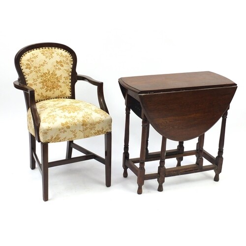 Oak drop-leaf table and open armchair with floral upholstery