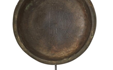 Property of a Gentleman (Lots 55-80) A Chinese bronze 'twin fish' bowl, Han dynasty, decorated to the interior with two fish and inscribed '富貴昌宜候王', with everted rim and rounded base, 19cm diameter, metal stand 漢代 銅雙魚碗 來源：紳士私人收藏