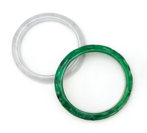 TWO CHINESE SIMULATED JADE BANGLE BRACELETS One green with carved dragon design, diameter 3", and one celadon, diameter 3".