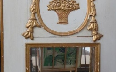 Trumeau en bois laqué gris à décor en bois sculpté et doré, le fronton à décor d'une corbeille de fleurs dans un tondo orné de guirlandes feuillagées, le miroir à décor de frises de perles