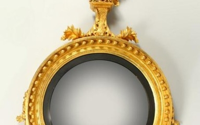 A REGENCY GILTWOOD CONVEX WALL MIRROR, with eagle