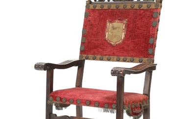 A 19th century Italian walnut armchair, top carved with rocailles and coat of arms.